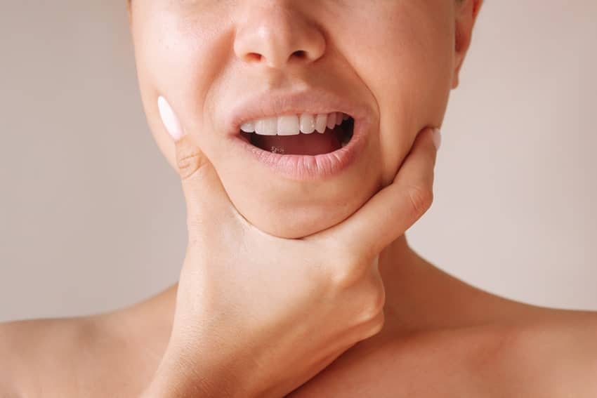 adult woman holding her jaw